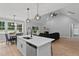 Open kitchen, dining, and living room area with an island, vaulted ceiling, and fireplace at 249 Rawhide Dr, Louisburg, NC 27549