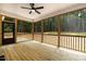 Cozy screened porch with wood flooring, a ceiling fan, and views of the surrounding woods at 249 Rawhide Dr, Louisburg, NC 27549