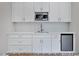 A bright wet bar features white cabinets, stainless steel appliances, and a white backsplash at 249 Rawhide Dr, Louisburg, NC 27549