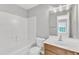 Bright bathroom features shower-tub combo with white tile and wood vanity at 2705 Wyntercrest Ln, Durham, NC 27713