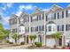 A row of townhomes featuring light gray siding and black shutters with attached garages at 2705 Wyntercrest Ln, Durham, NC 27713