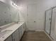 Bright bathroom featuring double sinks, quartz countertops, and a tiled shower with a glass door at 2874 Quarry Rd # 165, Rolesville, NC 27571