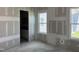 Unfinished bedroom with two windows and an open doorway to the en-suite bath, new construction at 2874 Quarry Rd # 165, Rolesville, NC 27571