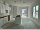 Bright, spacious kitchen with white cabinets, center island and sliding glass doors to the outside at 2874 Quarry Rd # 165, Rolesville, NC 27571