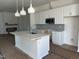 Open kitchen with a central island, white cabinets, quartz countertops, and stainless steel appliances at 2874 Quarry Rd # 165, Rolesville, NC 27571