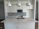 Close-up of a modern kitchen island with quartz countertops, stainless steel sink, and elegant pendant lighting at 2874 Quarry Rd # 165, Rolesville, NC 27571