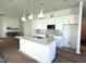 Stylish kitchen with white cabinets, a large island, modern pendant lights, and stainless steel appliances at 2874 Quarry Rd # 165, Rolesville, NC 27571