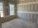 Unfinished living room featuring two large windows and prepped walls ready for painting at 2874 Quarry Rd # 165, Rolesville, NC 27571