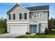 Charming two-story home showcasing light gray siding, a neatly manicured lawn, and a welcoming blue front door at 305 Spelt Ct, Rolesville, NC 27571