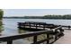 Wooden dock with benches overlooking a calm lake surrounded by lush greenery under a bright, sunny sky at 312 Calvander Ln, Apex, NC 27539