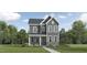 Charming two-story home with gray siding, stone accents, and a welcoming front porch at 312 Calvander Ln, Apex, NC 27539