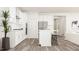 Well-lit kitchen with white cabinetry, island seating, and modern fixtures at 312 Calvander Ln, Apex, NC 27539