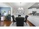 Open-concept dining area with modern chandelier, wood floors, leading to a kitchen at 322 Brier Crossings Loop, Durham, NC 27703