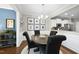 An elegant dining room features a dark wood table, modern chandelier, and adjacent to a kitchen at 322 Brier Crossings Loop, Durham, NC 27703