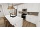 Modern kitchen featuring white cabinets, stainless steel appliances, and an island with seating at 332 Cottage Hl, Knightdale, NC 27604