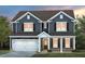 Charming two-story home featuring a welcoming front porch, attached garage, and professionally landscaped front yard at 353 Bridle Brook Way, Fuquay Varina, NC 27526