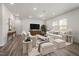 Spacious living room with neutral decor, hardwood flooring, large windows, and comfortable seating at 353 Bridle Brook Way, Fuquay Varina, NC 27526