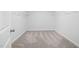 A walk-in closet with gray carpet flooring, white walls, and hanging racks at 353 Bridle Brook Way, Fuquay Varina, NC 27526