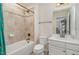 Bathroom with tiled tub and shower combo, white vanity, and light fixtures at 3609 Jordan Shires Dr, New Hill, NC 27562