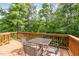Wooden deck surrounded by a lush green forest features an outdoor dining set for entertaining at 3609 Jordan Shires Dr, New Hill, NC 27562
