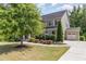 Beautifully landscaped home featuring a manicured lawn, mature trees, and attached garage at 3609 Jordan Shires Dr, New Hill, NC 27562