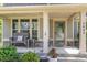 Inviting covered porch with stone accents, comfortable seating, and well-maintained landscaping at 3609 Jordan Shires Dr, New Hill, NC 27562