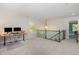 Carpeted loft area featuring a desk, wrought iron staircase, and natural lighting at 3609 Jordan Shires Dr, New Hill, NC 27562