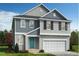 Charming two-story home featuring gray siding, black shutters, a turquoise front door and an attached garage at 368 Spelt Ct, Rolesville, NC 27571