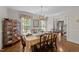 Formal dining room featuring hardwood floors, a chandelier, and ample natural light from large windows at 404 Emerywood Dr, Raleigh, NC 27615