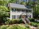 Charming two-story home featuring a gray roof, black shutters, and a lush, green, tree-filled yard at 404 Emerywood Dr, Raleigh, NC 27615