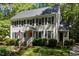 Charming two-story home featuring a red front door, black shutters, and a beautifully landscaped front yard at 404 Emerywood Dr, Raleigh, NC 27615
