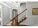 Bright foyer showcasing hardwood floors, a staircase with white railings, and a traditional chandelier at 404 Emerywood Dr, Raleigh, NC 27615