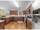 Well-lit kitchen features wood floors, granite counters, stainless appliances, and wood cabinets at 404 Emerywood Dr, Raleigh, NC 27615