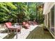 Inviting patio with brick pavers, multiple seating areas, lush landscaping, and mature trees create a backyard oasis at 404 Emerywood Dr, Raleigh, NC 27615