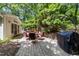 Picturesque patio with brick pavers, several seating areas, and lush backyard landscaping creates a relaxing outdoor space at 404 Emerywood Dr, Raleigh, NC 27615