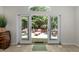 A view through glass doors onto a brick patio featuring lovely furniture and landscaping at 404 Emerywood Dr, Raleigh, NC 27615