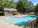 The community swimming pool features lap lanes, lounge chairs, and is surrounded by mature trees for a private experience at 404 Emerywood Dr, Raleigh, NC 27615