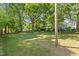 Grassy backyard with mature shade trees at 410 Caswell St, Burlington, NC 27217