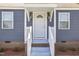 Close-up of the home's entrance, showcasing a white door, stylish lighting, and a well-maintained porch area at 410 Caswell St, Burlington, NC 27217