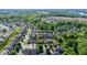 Aerial view showcasing a residential community with tree-lined streets and manicured lawns near a wooded area at 4116 Argyle Trl, Burlington, NC 27215