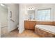 Bright bathroom featuring a soaking tub with decorative tile surround and updated vanity at 4116 Argyle Trl, Burlington, NC 27215