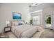 Staged bedroom features a tray ceiling, ceiling fan, light carpet, and an exterior door at 4116 Argyle Trl, Burlington, NC 27215