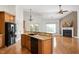 Open kitchen with wood cabinets, black appliances, granite countertops, and hardwood flooring at 4116 Argyle Trl, Burlington, NC 27215