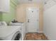 Laundry room with washer, dryer, overhead shelving and white door at 4116 Argyle Trl, Burlington, NC 27215
