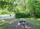 A lush backyard features a covered pool, fire pit, and mature trees, offering privacy at 4205 Woodlawn Dr, Raleigh, NC 27616