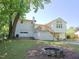 Back exterior features deck with stairs, fire pit, mature trees, and lush, green lawn at 4205 Woodlawn Dr, Raleigh, NC 27616