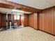 Basement with workout equipment, wood paneled walls and tile floors at 4205 Woodlawn Dr, Raleigh, NC 27616