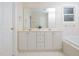 Bright bathroom with double sink vanity, large mirror, and white tiled floor at 4205 Woodlawn Dr, Raleigh, NC 27616