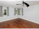 Bedroom with hardwood floors, neutral walls, large windows and ceiling fan at 4205 Woodlawn Dr, Raleigh, NC 27616