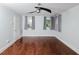 Bright bedroom showcasing hardwood floors, a ceiling fan, and ample natural light from multiple windows at 4205 Woodlawn Dr, Raleigh, NC 27616